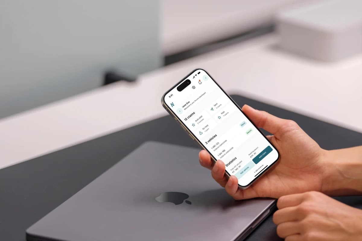A hand holding an iPhone showing the Nuvoni app