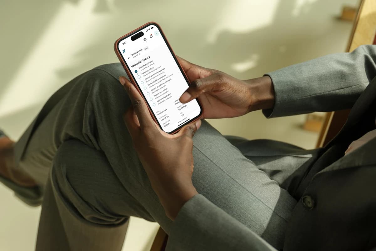 Hand holding iPhone showing Nuvoni app